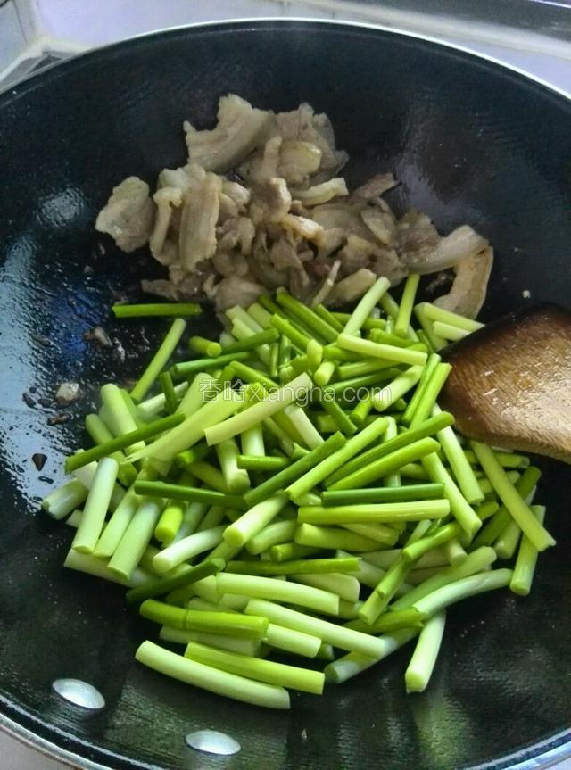 把五花肉扒到锅边倒入蒜苔，红椒条煸炒出香味，加盐把五花肉和蒜苔炒均匀入味，加老抽上色，加生抽提味。