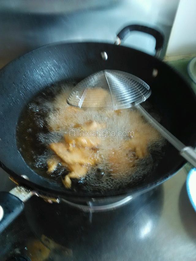 把炸过的肉片在一次倒入油中炸片刻即捞出。