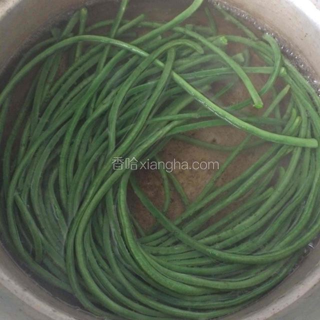 择好的豇豆整根放入开水里面煮两分钟左右，一定要断生哦！