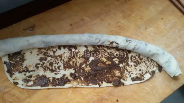 从一边抻拉着卷起。