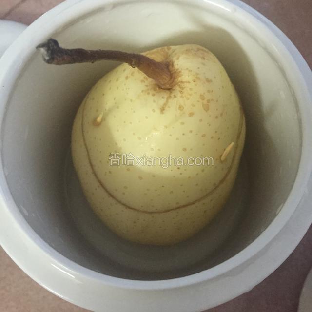 用牙签把雪梨的顶部与身部固定，还完成一个雪梨的样子，放进盅了，加一点点水，刚过雪梨底部就够了，不能放太多。