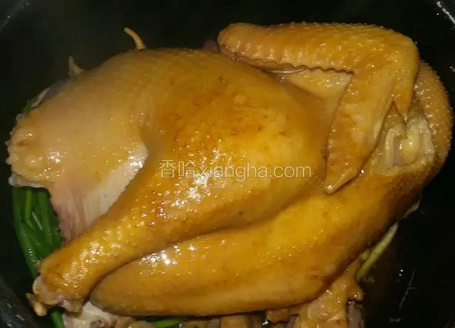 电饭煲里先放几根完整的葱  几片姜  然后倒点酱油