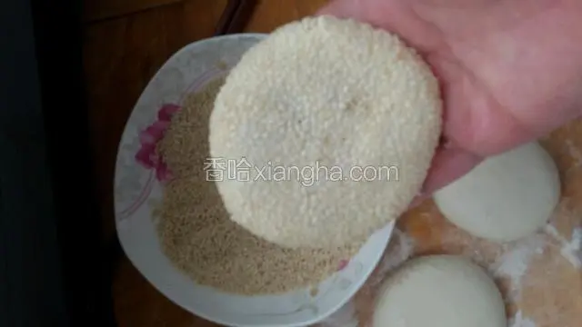 用淡盐水抹在包好面挤上，粘均匀白芝麻。