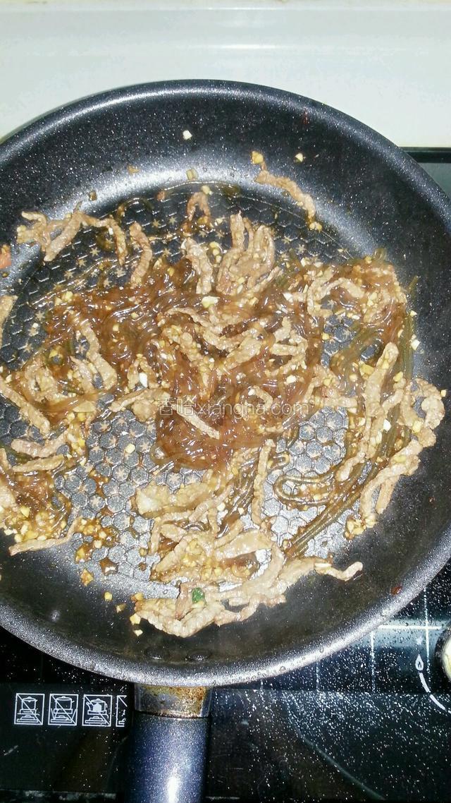 牛肉炒熟后加入煮好的粉条和蒜蓉酱翻炒几下后关火