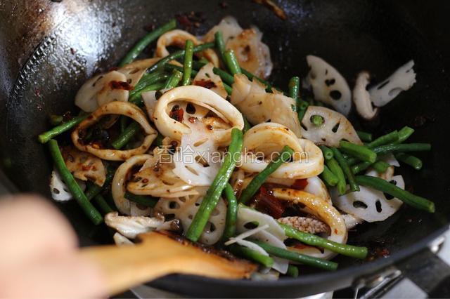 放入鱿鱼圈和蔬菜翻炒，使酱汁均匀裹住食材。