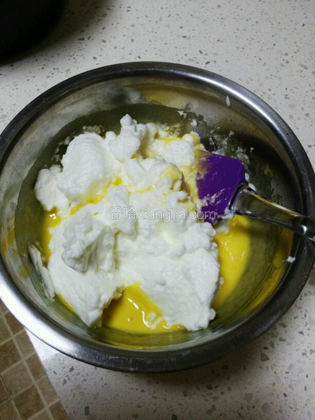 把三分之一的蛋白加入到蛋黄液中，用刮刀上下翻匀