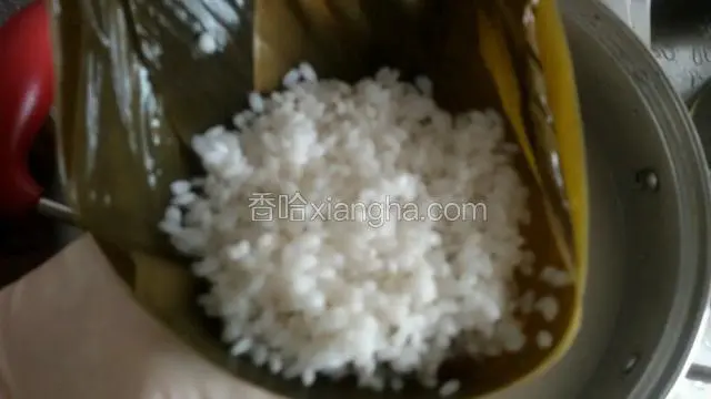 在装入另一半糯米，淋入点泡米水，使之密实