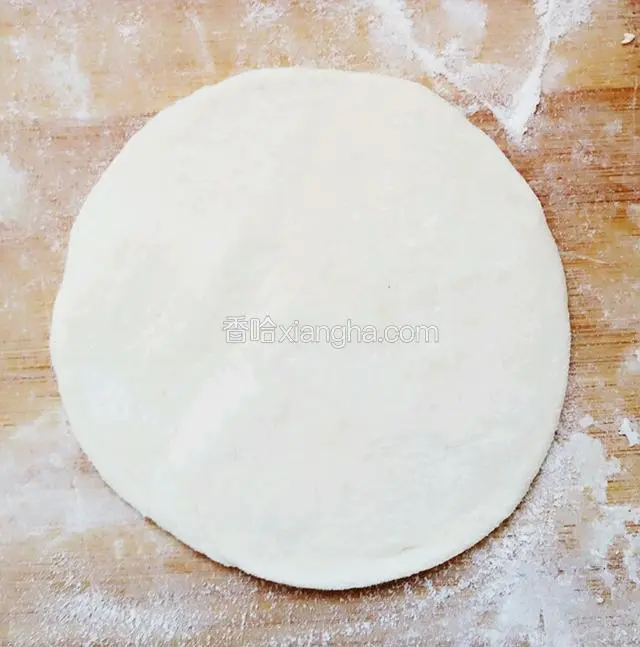 把剂子压扁，用擀面杖擀成中间厚，边缘薄的面片