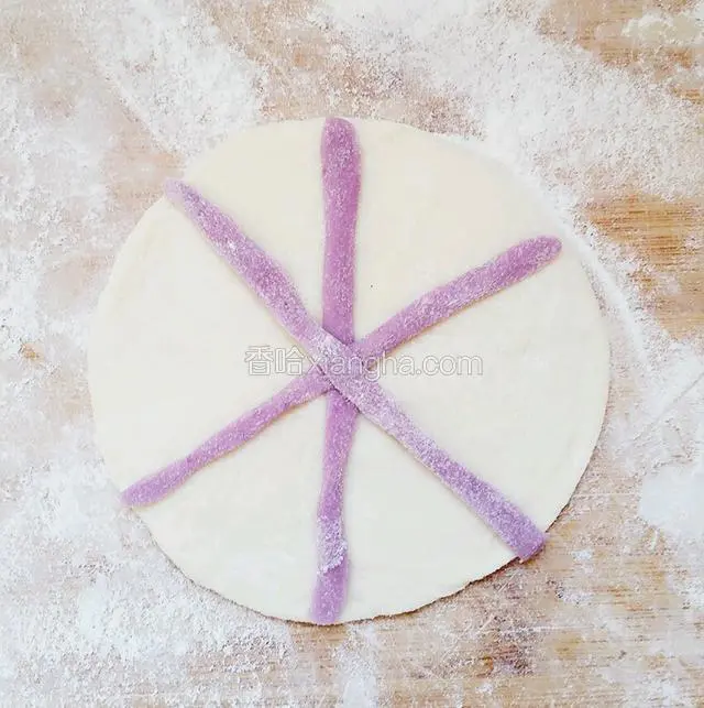 取一点紫薯和面混合揉成的面，搓成很细的装饰条，成米子贴在面片上