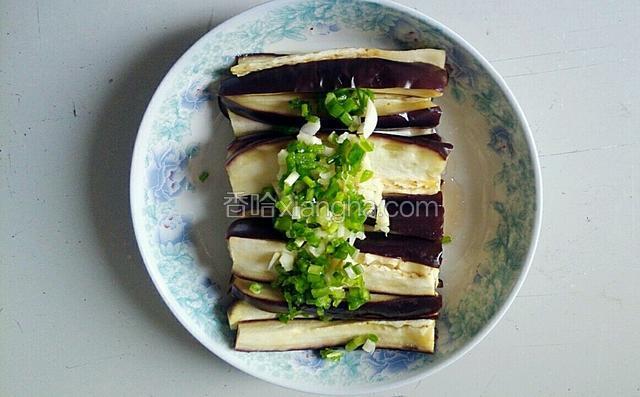 与适量盐一起放在蒸好的茄子上，，并起油锅，油烧到八层热左右关火，快速将热油烧在葱，蒜，青椒，盐的上面