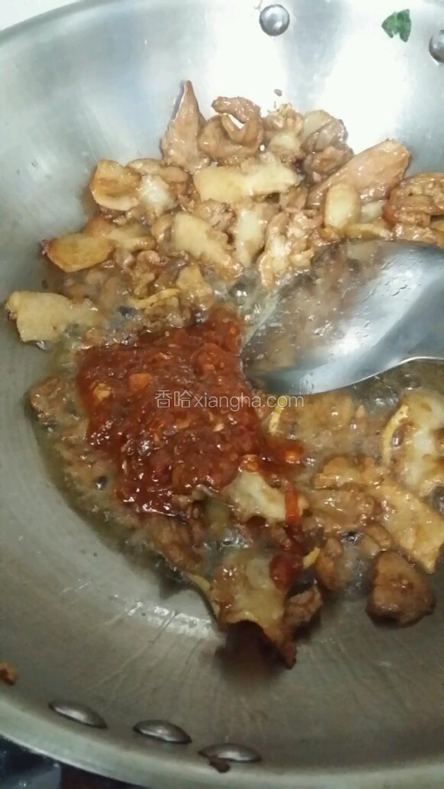 肉片变色以后放入郫县豆瓣酱，随后放入葱蒜沫