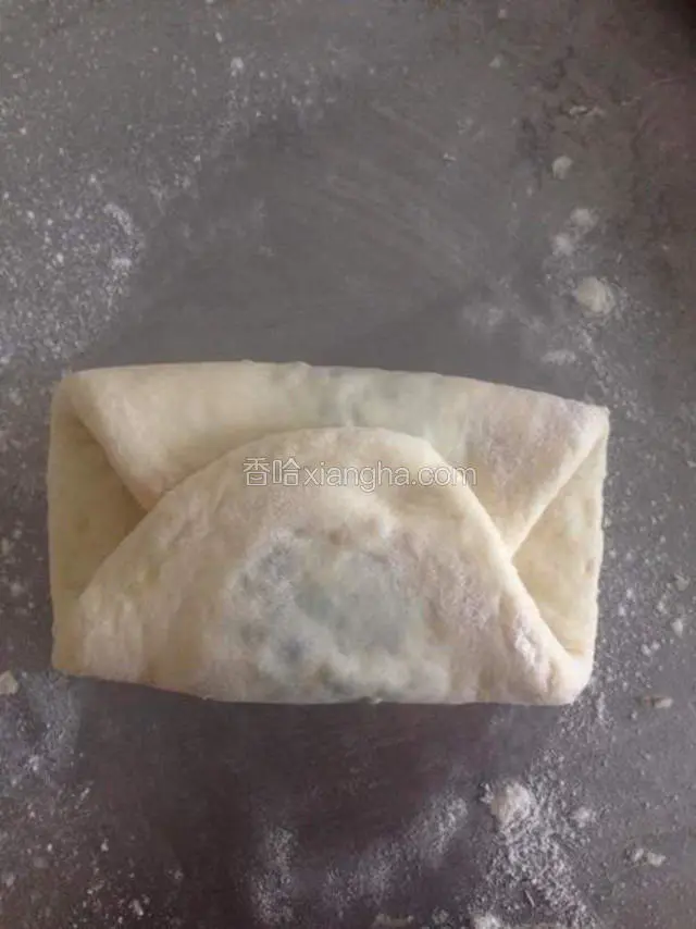拍少许手粉。擀成长舌状。两边往中间对折。