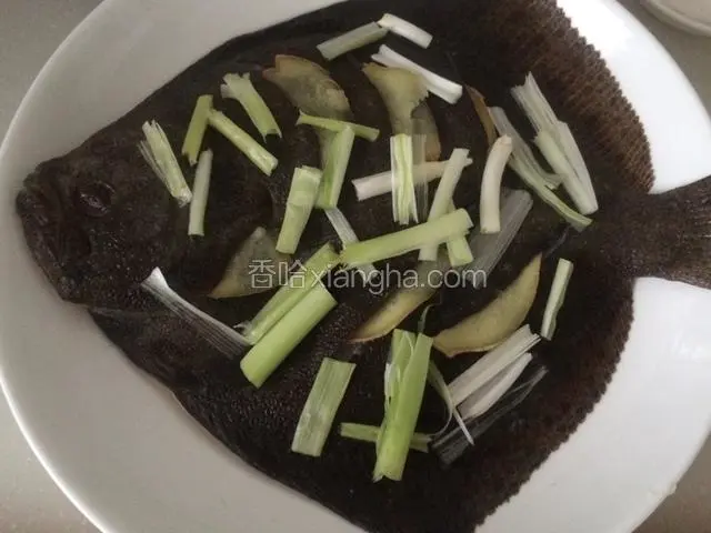 把姜片分别塞入鱼身切口处、腹中和鱼头位置，葱白段均匀撒在鱼身上，待蒸锅里水烧开后，把鱼放里；