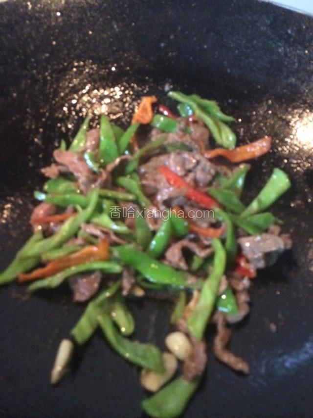 牛肉片炒至变色后加入炒好的青红椒，继续翻炒一分钟左右