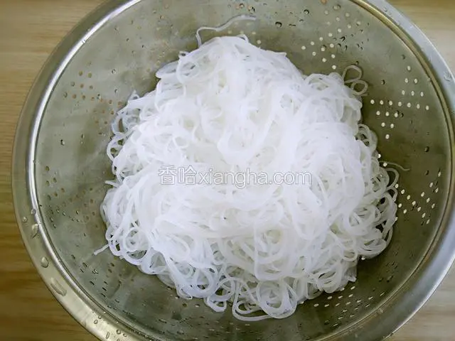 将粉丝捞出在水龙头下冲凉随后用剪子剪短粉丝备用