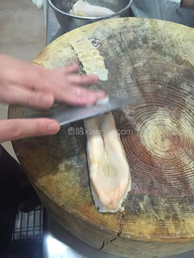 把象拔蚌平铺在砧板上斜刀切片