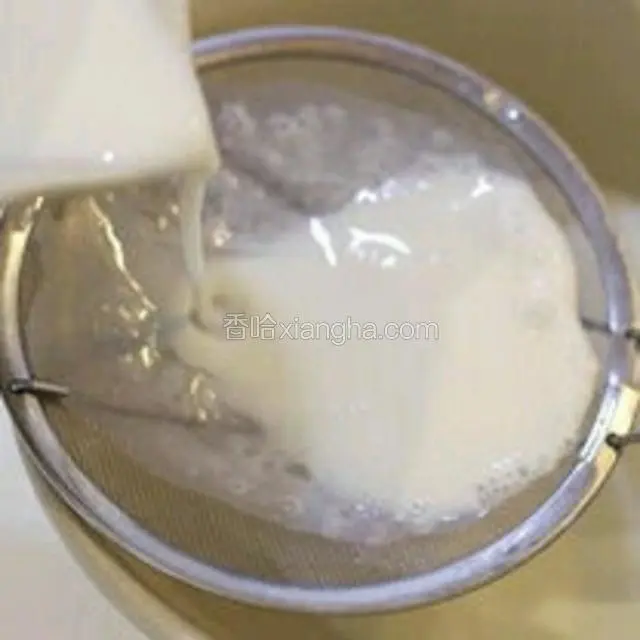 再把混合后的牛奶用筛网倒入留有奶皮的碗里，慢慢沿着边倒，奶皮就会浮起来