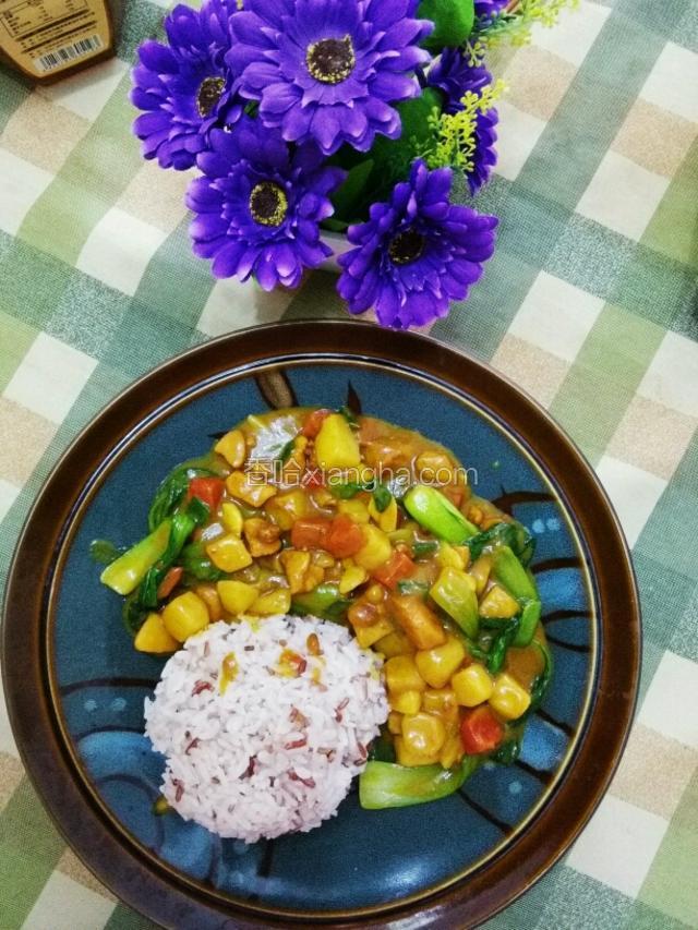 蒸好的米饭盛入盘中，浇上煮好的咖喱鸡块，美味的咖喱鸡块饭就可以享用了