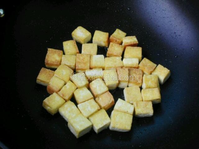 豆腐入锅中煎至金黄色盛出待用，当然在油锅中炸也可以。 