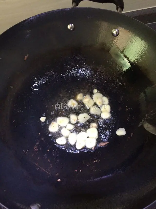 锅内再放油，把蒜片煸炒出香味。 
