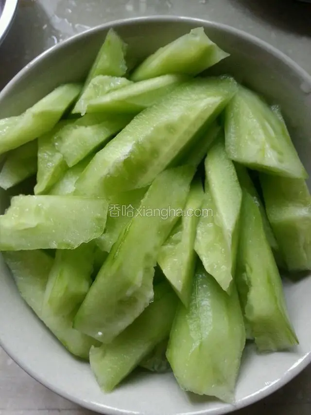 青瓜削皮斜切成块，备用。