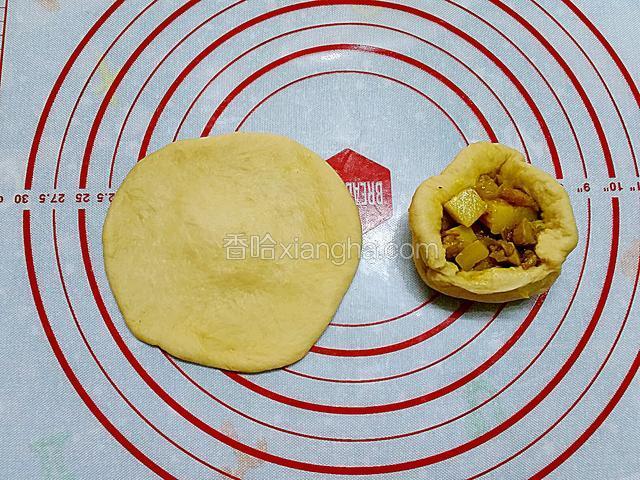 將小麵團擀開中間厚邊緣薄的麵片，放上咖哩雞粒饀料包成圓形，收口處捏實並朝下放