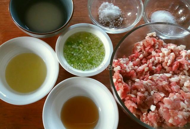 逐一在肉团中加入白糖、料酒、蛋清和葱姜水（葱、姜滤去不用），一边摔打肉团，一边陆续加入各种材料。