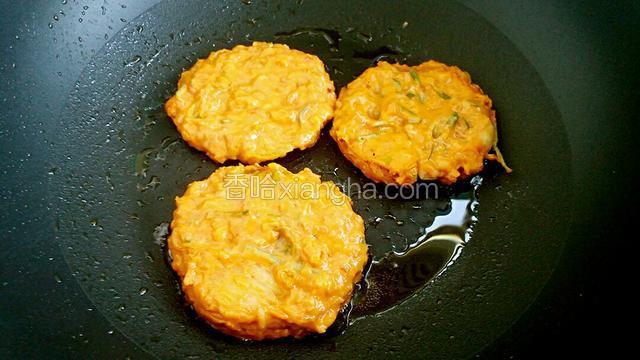 平底锅放油烧热，用勺子舀适量饼糊倒入锅中压成饼状，用小火煎好一面再煎另外一面。