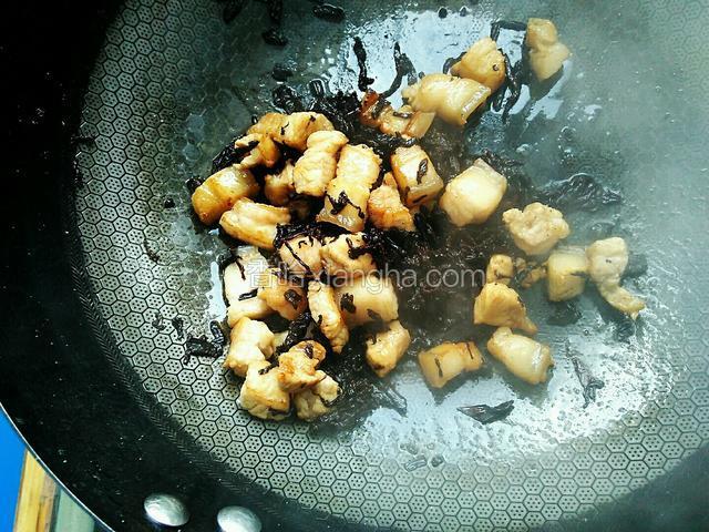 翻炒均匀，使梅干菜和五花肉均匀混合。