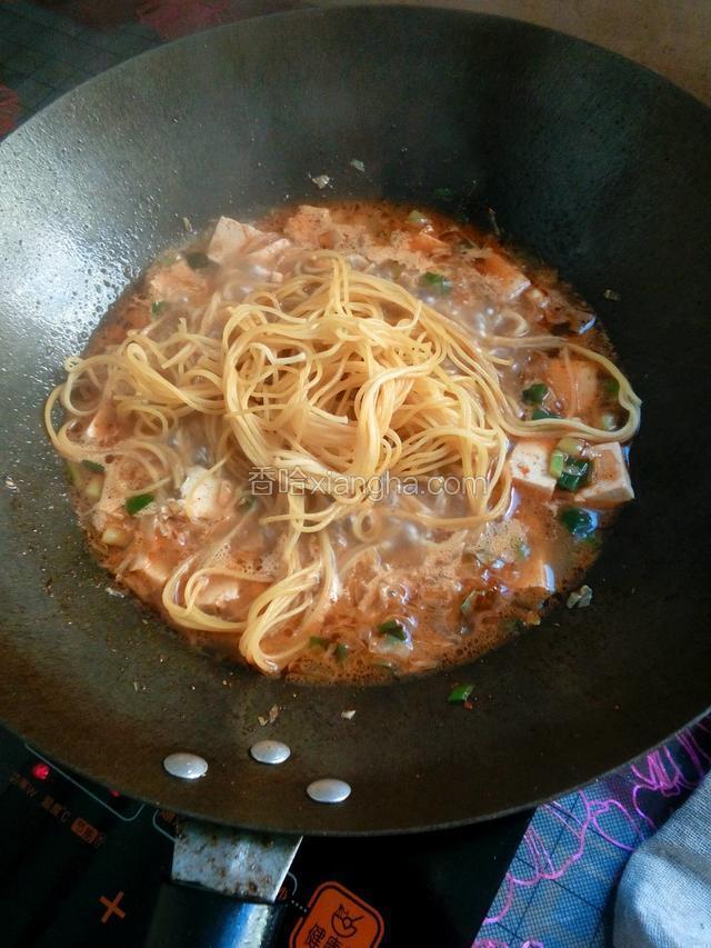 蒸好的饸饹放入炒菜锅里，用筷子抖开