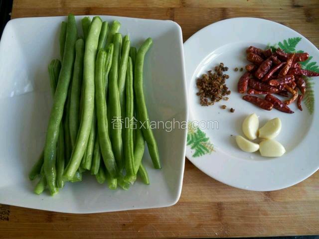 四季豆去两头筋洗净沥干备用，蒜米，花椒，干辣椒洗净备用