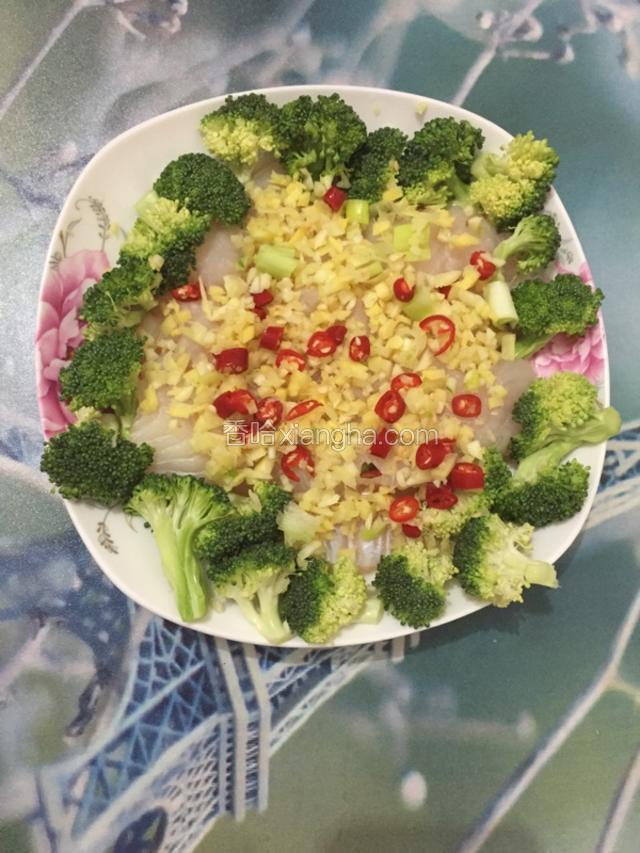 先把切好的姜丝铺在盘底，然后把鱼和西兰花摆盘，切碎的葱姜蒜辣椒铺在鱼上面