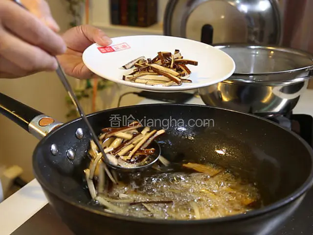 锅中烧热，下入色拉油150克，大火烧至六七成热，下入切好的熏干拉下油，捞出备用。