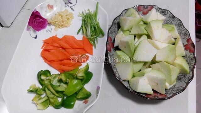 利用腌肉的时间准备好其它食材，茄子去皮切块，胡萝卜切菱形片，青椒切成块状，蒜切末，葱切成丝。