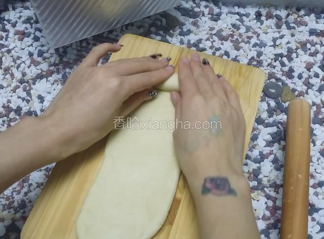 松弛好的面团擀成长舌状，然后从一头卷起