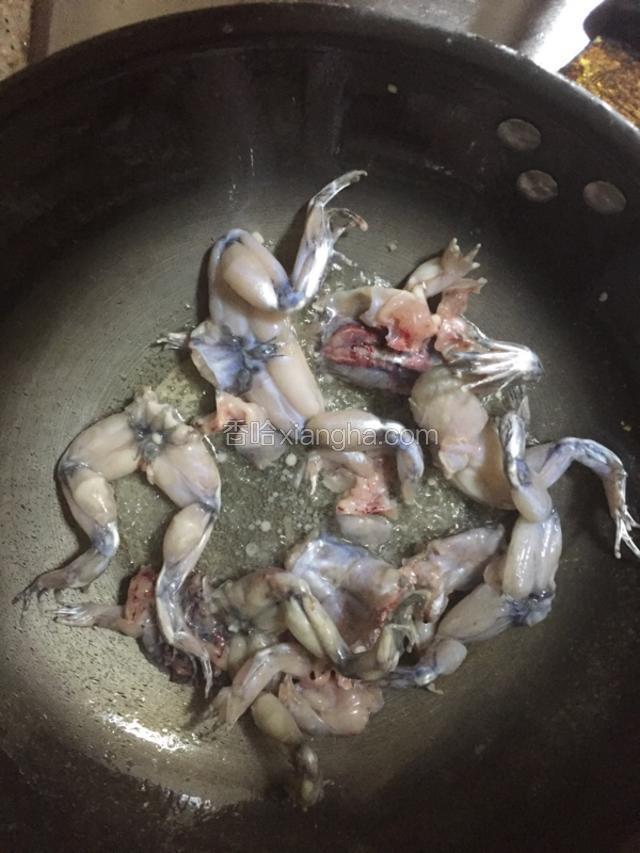 起锅放油五成热，下腌好田鸡滑熟捞出待用