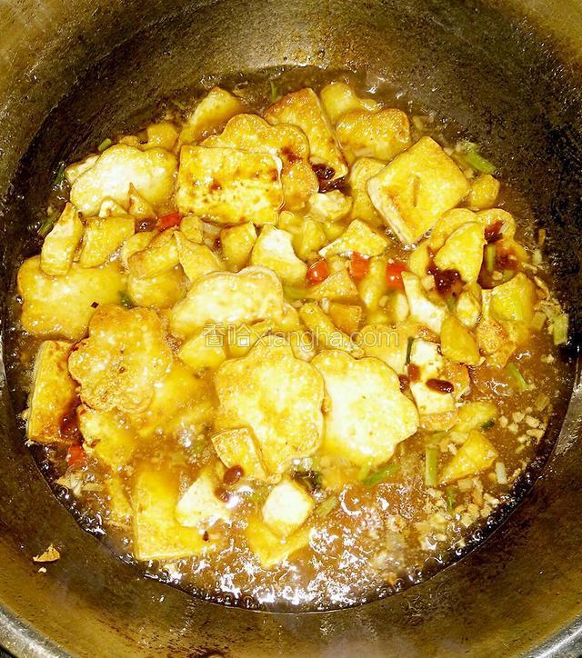 加入黄豆酱继续翻炒，加入适量的水，水的量没过豆腐，小火焖煮