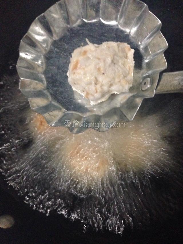 锅里加入适量的食用油，油最好多一些。然后用手挤萝卜丸子。放入油锅里，中火炸至变黄。