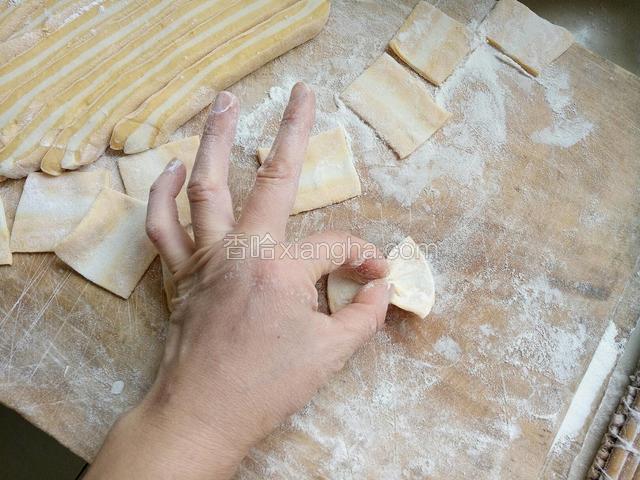 取一个方形面片，用拇指和食指从相对的两条边的中心往中间捏紧