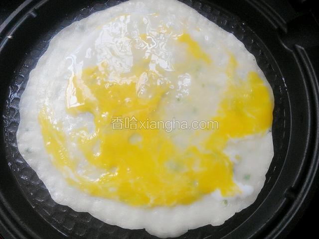 将一个鸡蛋直接打在饼上，用锅铲将鸡蛋打散，使蛋液均匀的铺在饼上！