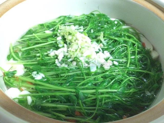 豌豆苗变色后放入切好的葱蒜末；