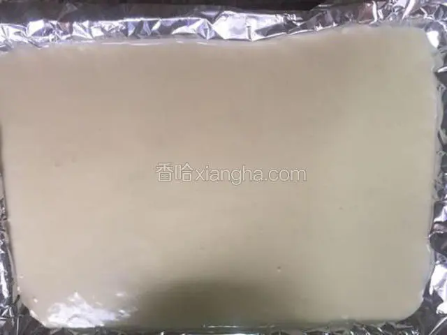 烤盘铺上锡纸，然后把蛋糕糊倒入，抹平，然后拿起烤盘震一震，