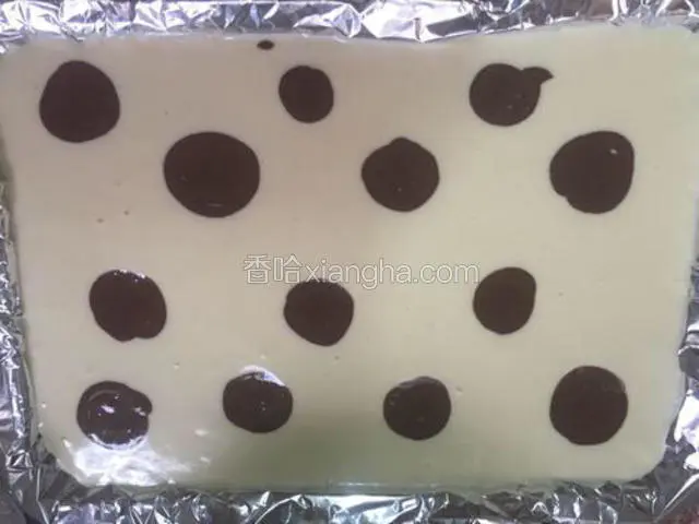 把可可糊在蛋糕糊表面挤上圆形（也可挤自己喜欢的形状），作奶牛花纹
