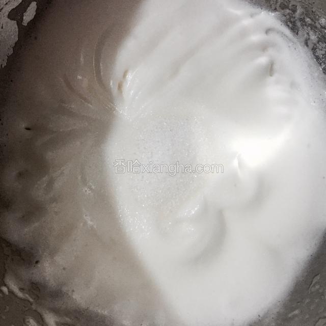 高速打发蛋白至湿性发泡，出现明显纹路，用打蛋器能拉起来角且不坚挺会倒下去的状态，加入剩下所有的白糖。