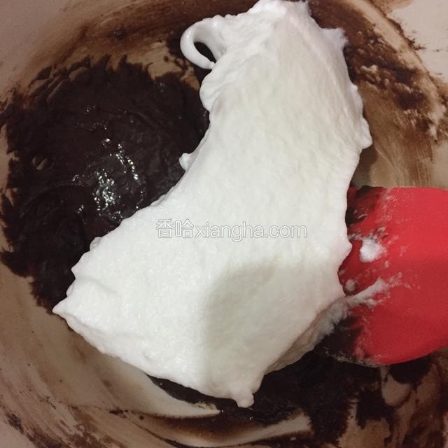先取三分之一的蛋白到可可面糊里，用翻拌炒菜的手法将面糊搅拌均匀。