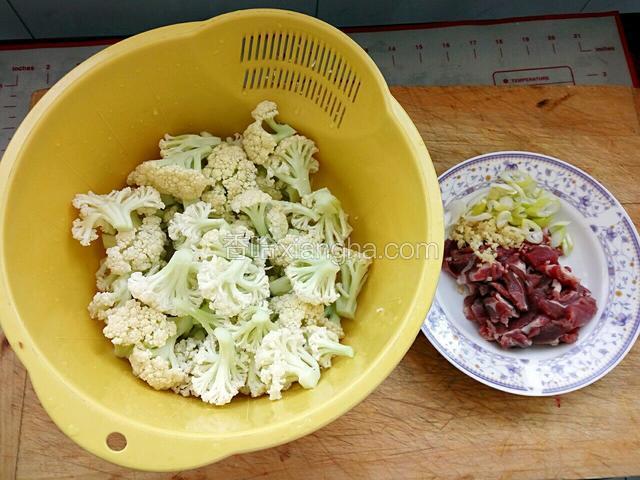 菜花用盐水泡一会，在用水冲洗干净，牛肉切片，葱姜切末