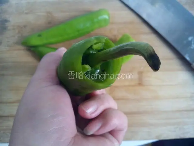 左手捉紧青椒，右手拿着椒蒂位置用力一按，椒蒂就会陷进去了。