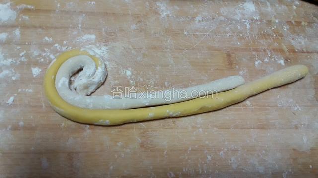 现在做棒棒糖，黄色白色面分别搓成条状，然后像下面这样卷起来