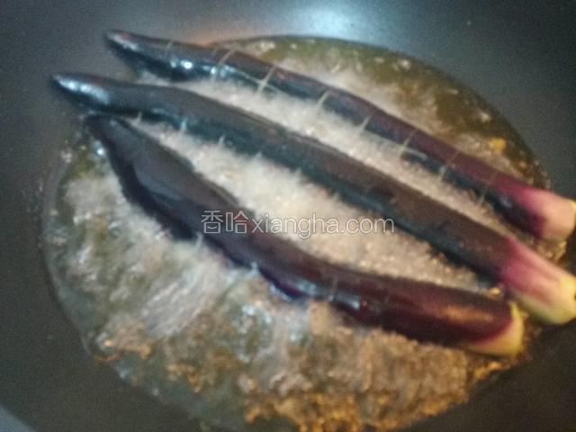 锅中烧热油，油温烧至六成热，下入茄子炸制7分钟。