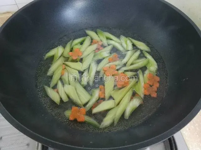 锅中烧热水，下入腰果焯水1分钟，沥水捞出备用，锅中放入少量油，少量盐，将西芹，胡萝卜焯水1分钟，捞出备用。